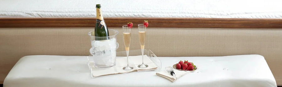 Champagne chilling in an ice bucket with two flutes, fresh strawberries, and a serving tray arranged for elegant home entertaining.