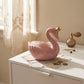 Light pink ceramic swan bank, 6 inches x 6.75 inches x 4 inches, adorned with a small gold crown. A whimsical and elegant decorative coin bank for children or adults.
