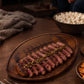 Football-shaped wood board, 18" x 11", made of dark Acacia wood with detailed football stitching. A game-day serving board for snacks and appetizers.
