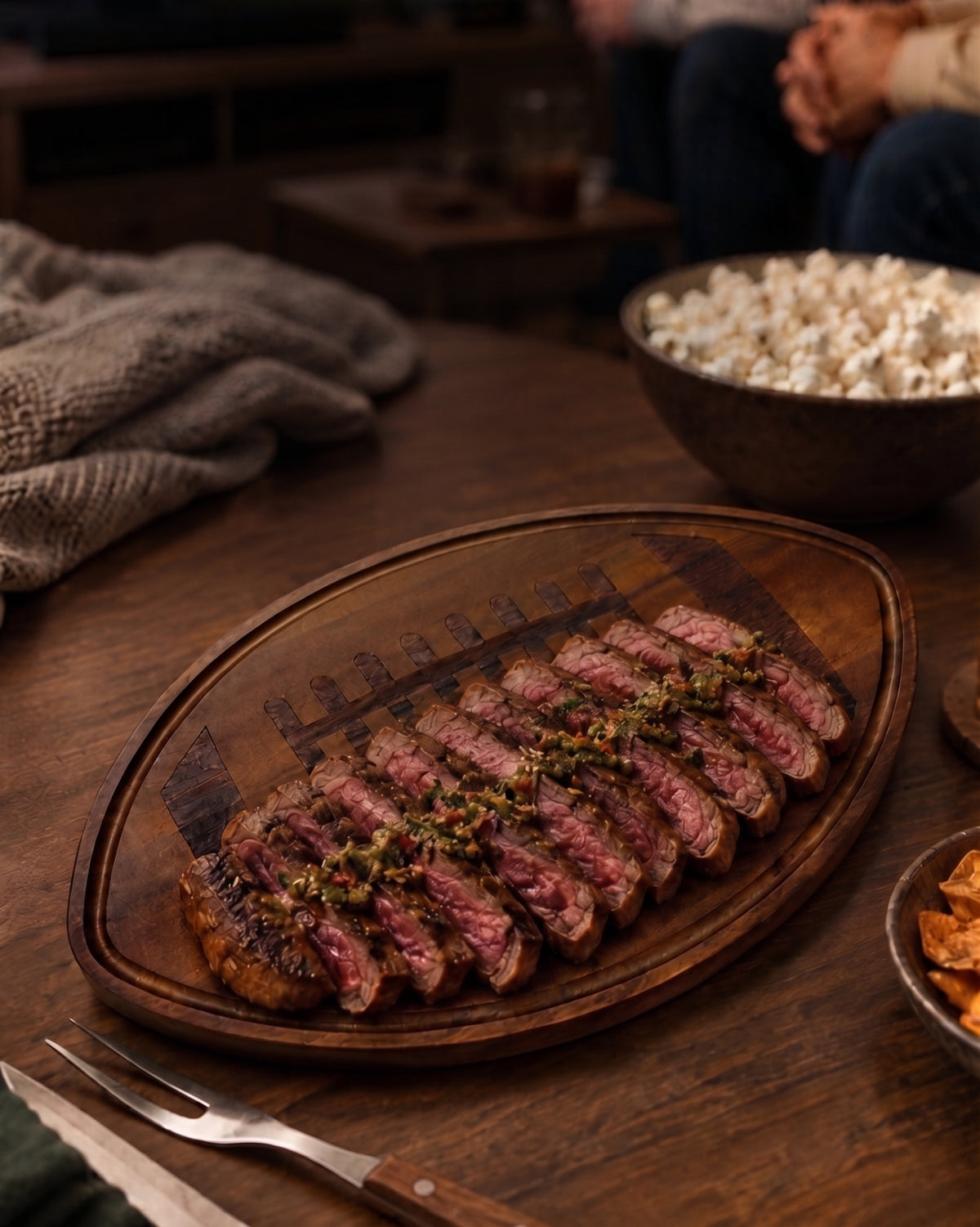 Football-shaped wood board, 18" x 11", made of dark Acacia wood with detailed football stitching. A game-day serving board for snacks and appetizers.
