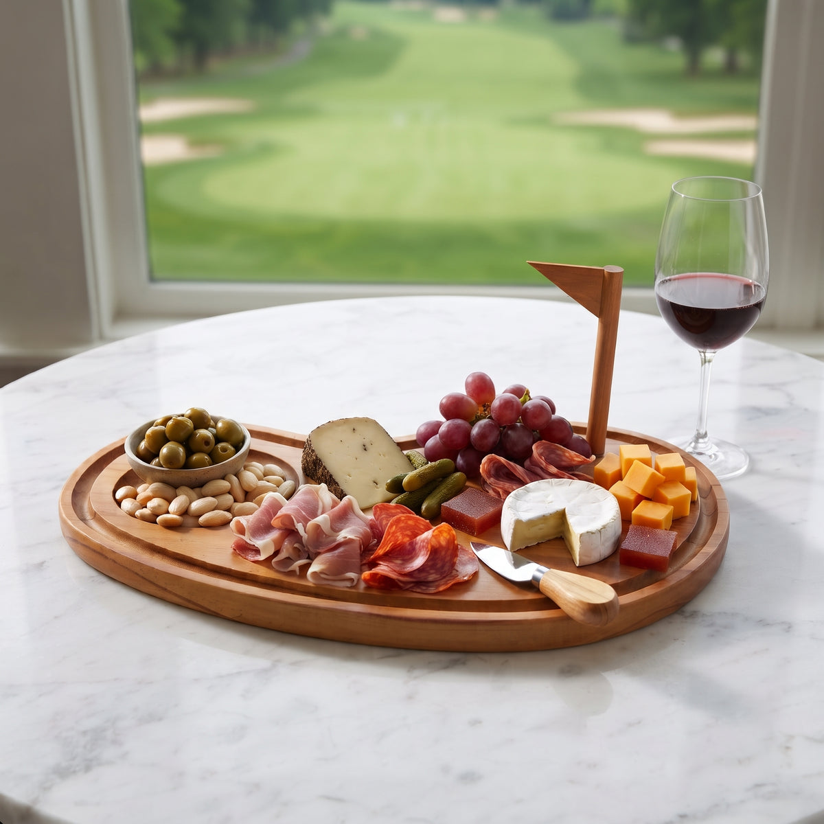 Golf Course Wood Board, 15 inches x 8 inches, made of natural pine wood and shaped like a putting green. Features a recessed sand trap, removable flag pole, and catch-all moat around the edge for serving appetizers.