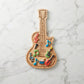 Guitar-shaped wood serving board, 9 x 17 inches, featuring electric guitar detailing and a grooved edge, ideal for serving snacks, cheese, and charcuterie.

