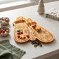 Mittens-shaped wood serving board, 10.75 x 15.75 inches, made from pine wood with festive snowflake, reindeer, tree, and polka dot details for holiday serving.
