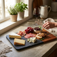 Black marble and acacia wood diagonal serving board, 12 x 7.75 inches, featuring a modern design for serving cheese, charcuterie, appetizers, and snacks.
