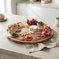 White marble stripe and acacia wood round serving board, 11-inch diameter, for charcuterie, serving, and food prep.