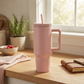 Pink stainless steel tumbler with a 40 oz capacity, handle, and removable straw, featuring a sleek modern design and measuring 12 inch x 6.25 inch.
