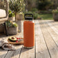 Orange 36 oz stainless steel water bottle with twist-off cap, featuring a sleek reusable design for keeping drinks hot or cold throughout the day.
