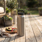 Silver 36 oz stainless steel water bottle with twist-off cap, featuring a sleek reusable design for keeping drinks hot or cold throughout the day.
