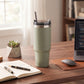 Sage green 30 oz stainless steel tumbler with straw, featuring a compact handle-free design for keeping drinks hot or cold on the go.
