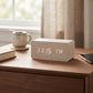 White wood wireless phone charger and digital alarm clock with LED time, date, and temperature display, made from smooth bamboo with up to three alarms.
