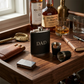 Black leatherette flask and stainless steel shot glass gift set, featuring an 8 oz flask, two matching shot glasses, and a presentation box, making a sophisticated Father’s Day gift.