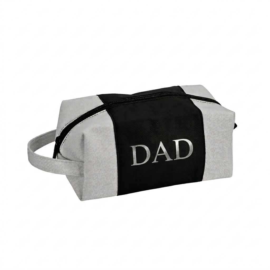 Black leatherette and canvas travel kit with a classic Dopp kit design, zipper closure, carry handle, and custom silver engraving, making it a practical Father's Day gift.