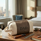Grey leatherette and canvas travel kit with a classic Dopp kit design, zipper closure, and carry handle, a practical Father's Day gift for organizing travel and grooming essentials.
