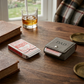 Grey leatherette playing card case with a snap closure and included poker cards, making a thoughtful Father’s Day gift for card game enthusiasts.