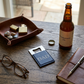 Navy leatherette and stainless steel bottle opener, 3.5 x 2 inches, with a laser-engravable surface and gift box, making a practical Father's Day gift.