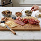 Engraved American Flag-shaped acacia wood serving board in a natural brown finish, designed for charcuterie, cheese, fruit, or appetizers, and suitable for personalization as a unique gift.
