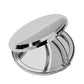 A partially open, round, nickel-plated Boston compact mirror with a shiny finish, reflecting light on its surface.